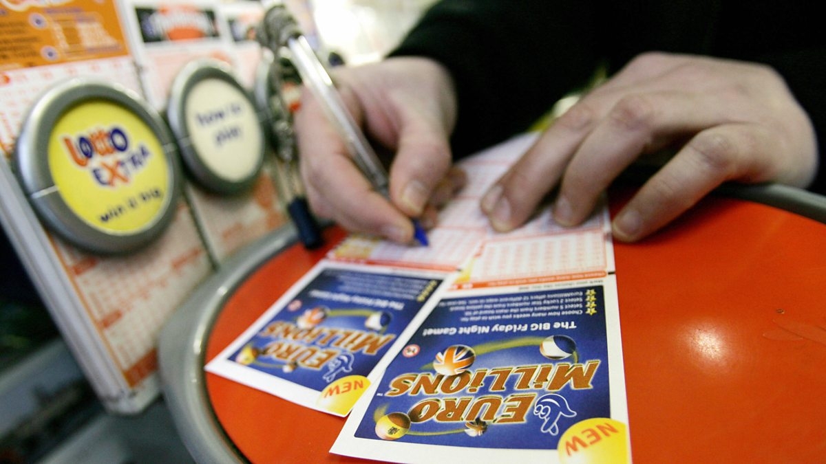 Руки, игрока, заполняющего билет EuroMillions