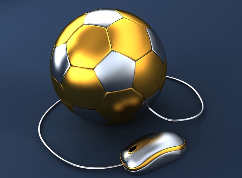 Золотисто-серебряный футбольный мяч и присоединенная к нему компьютерная мышка