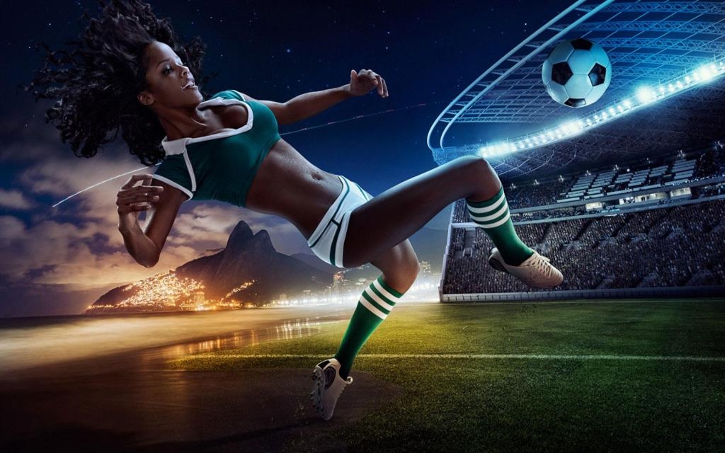 Стройная негритянка в откровенной форме для футбола отбивает мяч в прыжке