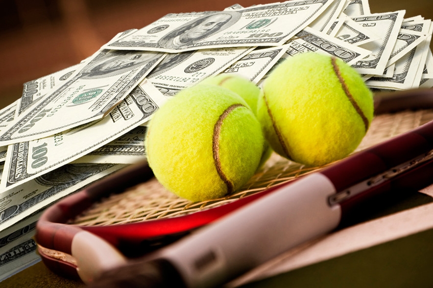 В теннисной ракетке лежат два мяча, а рядом куча стодолларовых купюр