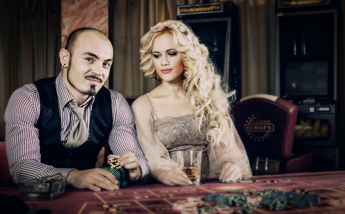 Богатый мужчина развлекается в казино в компании роскошной блондинки