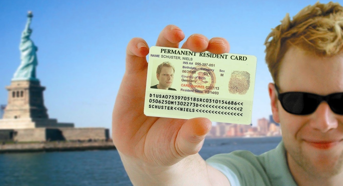 Рыжеволосый парень радуется выигрышу Грин-карты