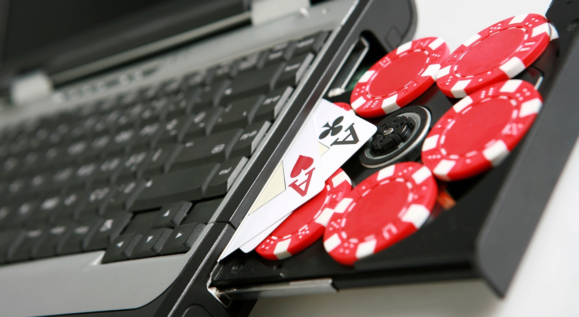 На дисководе ноутбука лежат фишки и карты