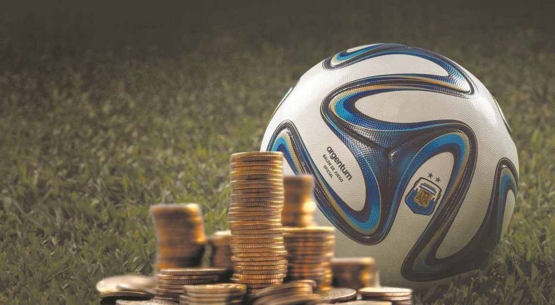 Футбольный мяч и стопки золотых монет