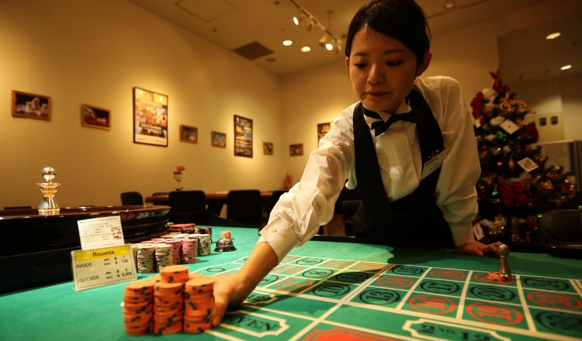 Девушка-крупье готовит слот для игры в рулетку