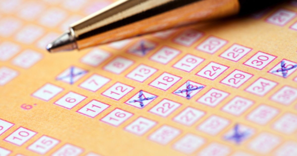 Ручка лежит на зполненном лотерейном билете