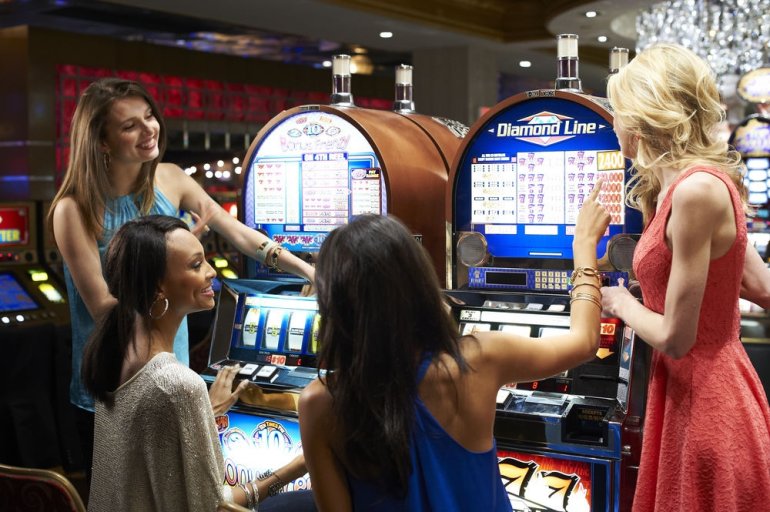 Четверо подруг советуются перед игрой на автоматах в казино