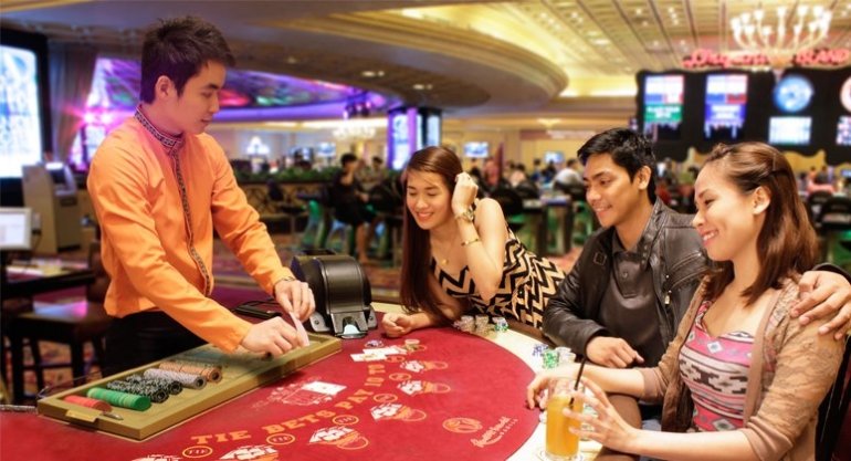 Красотки азиатской внешности играют в казино в компании молодого симпатичного крупье