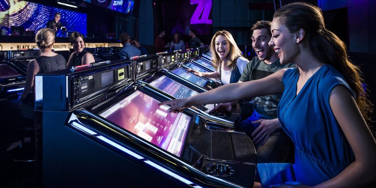 Несколько симпатичных молодых женщин играют на автоматах в дорогом казино