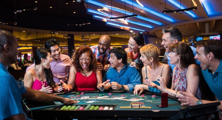 Люди разных национальностей играют в блэкджек в дорогом казино на курорте