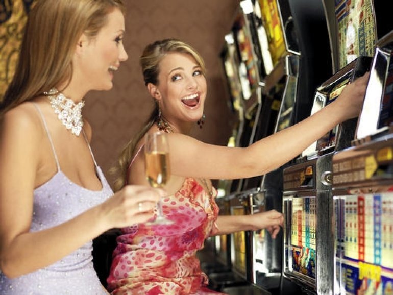 Двое роскошных дам играют на автоматах, выпивая шампанское
