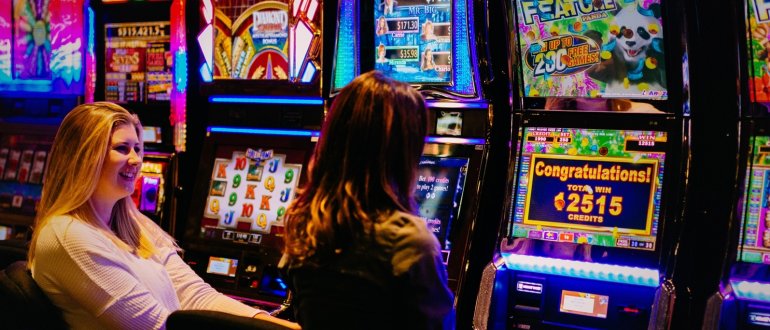 Подруги проводят время за игрой на автоматах в казино