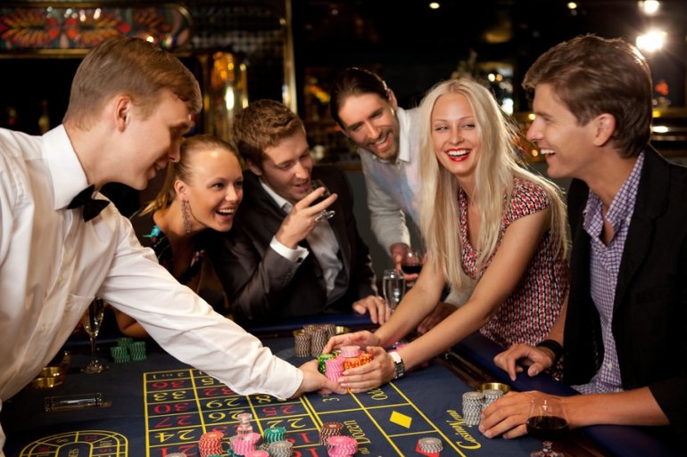 Молодая компания играет в рулетку в престижном казино