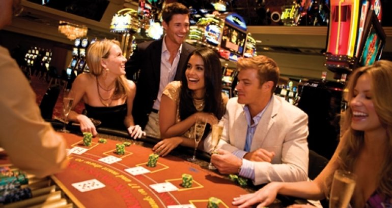 Компания молодых людей за игрой в блэкджек в казино