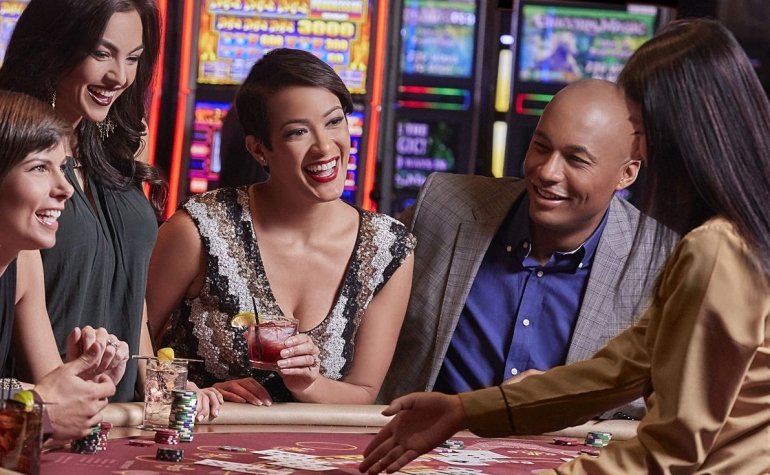 Веселая компания хорошо проводит время за игрой в казино