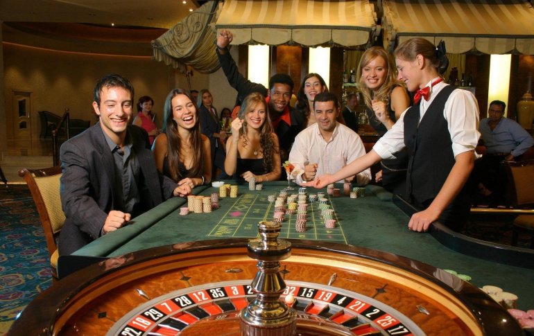 Компания азартных туристов отрывается за игрой в рулетку в казино на курорте