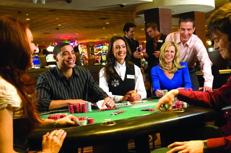 Дилер ведет игру в блэкджек для девушек и мужчин, которые пришли развлекаться в казино