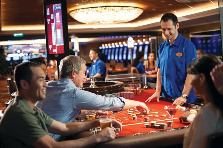 Мужчины распивают алкоголь, играя в рулетку в престижном казино