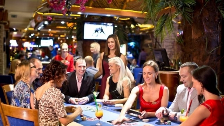 Радостная компания на отдыхе играет в казино