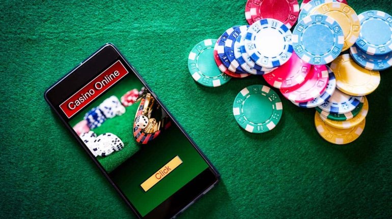 Смартфон с открытым онлайн казино лежит на столе для игры в покер